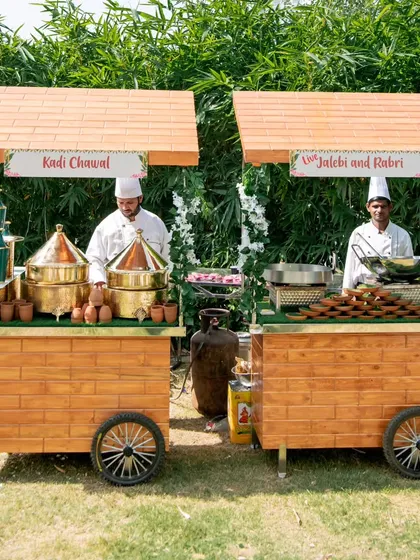 I bring the authentic charm of Indian street food to your event with these beautiful live 'thela' carts. Here you can see our chefs serving fresh Kadhi Chawal and hot Jalebi with Rabri, creating an interactive and memorable dining experience.