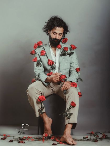 A surreal and artistic portrait where beauty and pain coexist. The roses pinned to his suit tell a story of resilience, of blooming despite the thorns.