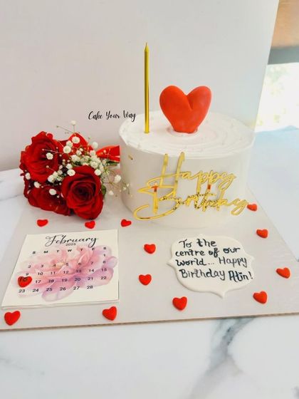 A sweet and simple birthday cake platter. This one includes a personalized message, a calendar marking the date, and a small bouquet of fresh red roses to complete the celebration.