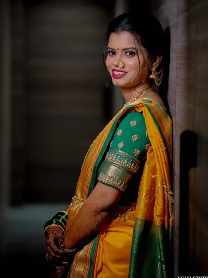 A portrait of a radiant Maharashtrian bride. Her makeup is kept subtle to let her traditional yellow and green saree and jewelry shine.
