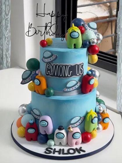 Game on! This two-tiered "Among Us" themed cake is perfect for any young gamer's birthday, complete with colorful, handcrafted crewmates and flying saucers for an out-of-this-world celebration.