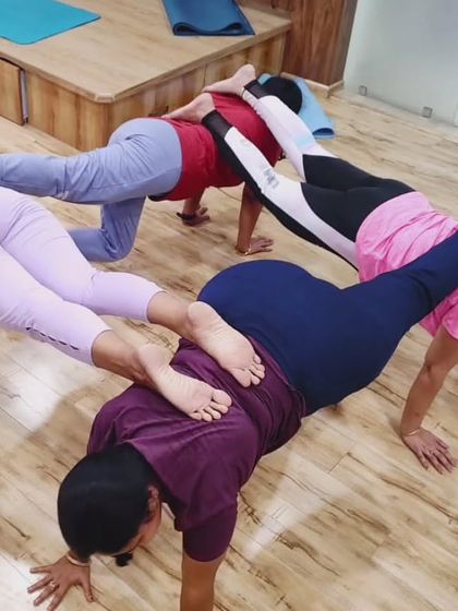 This interlocking plank pose requires core strength and coordination from everyone involved. It's a great example of our playful approach to building strength.