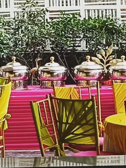 Another view of the pooja event catering, showing the buffet line against a backdrop of lush greenery. This setup is perfect for a daytime celebration.