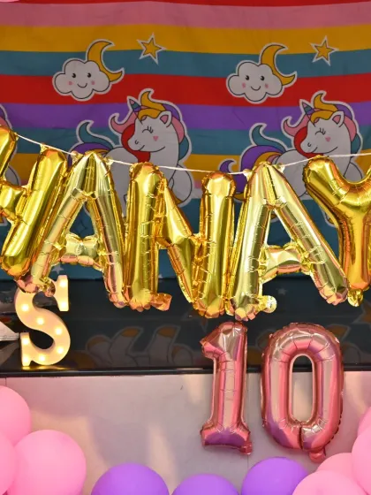 The personalized 'SHANAYA' foil balloons against the colorful Unicorn backdrop.