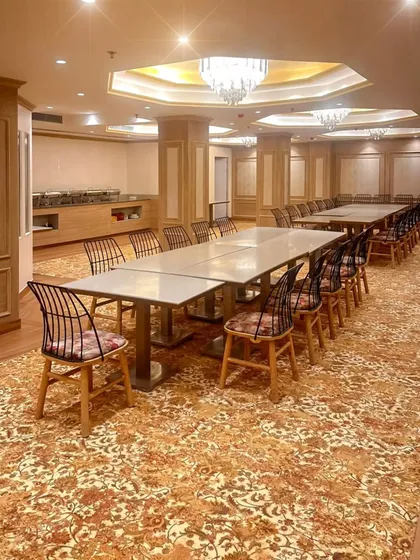 A closer look at the party hall's layout, showing the seating arrangement and the adjacent buffet area. The design ensures smooth flow and functionality for large gatherings, making it a versatile space for various hospitality functions.