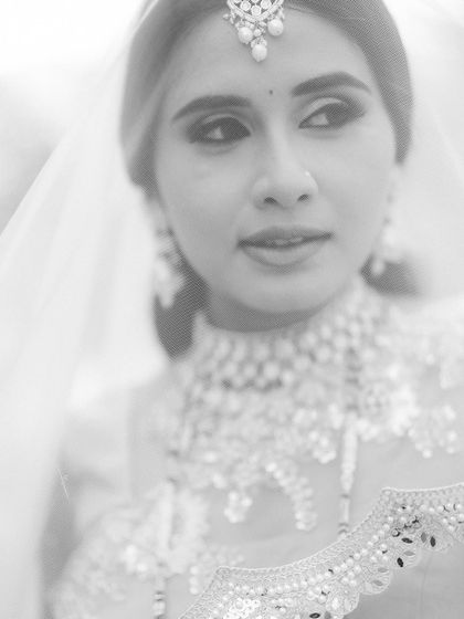 A soft and dreamy close-up of the bride. The high-key black and white effect and the veil create a delicate, ethereal portrait, focusing on her beautiful features.