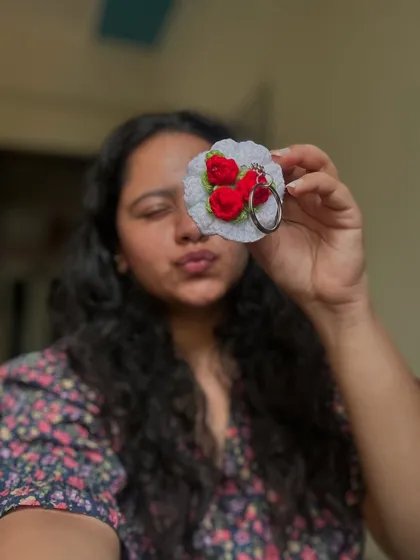 A selfie showing off one of my mini rose bouquet keychains. They are so detailed and pretty.