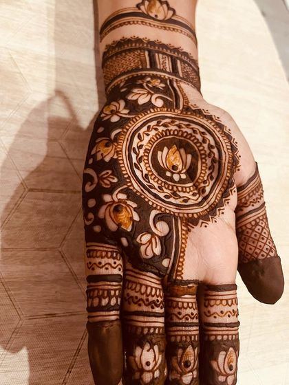 This palm design features a large, bold mandala with a lotus at its center. The use of negative space makes the floral patterns around it really stand out.