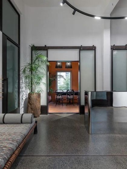 The reception area of the ADND SILO office, with its mirrored desk and industrial-style sliding doors, reflects the firm's ethos of transparency and reinvention.