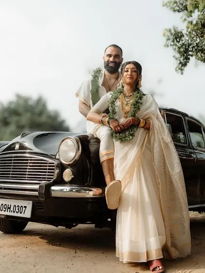 A stylish couple portrait against the backdrop of a vintage Ambassador car. We love incorporating unique elements into our shots, blending classic elegance with modern style for truly memorable South Indian wedding photography.