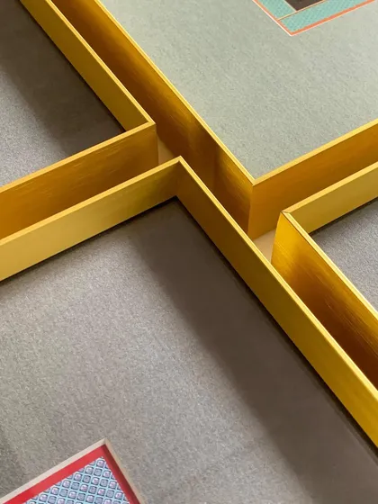 A close-up of the corners of the gold metal frames, showing their clean lines and how they come together to form a perfect grid for a gallery wall.