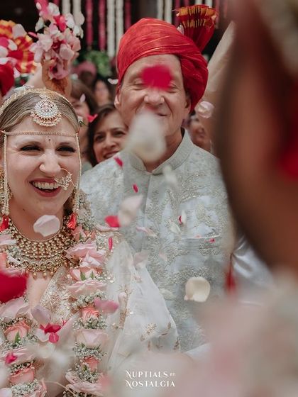 The bride's joyful, laughing face as she is showered with petals by her family and friends.