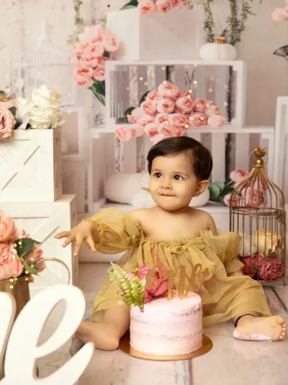 A thoughtful glance before digging in. This floral-themed cakesmash session uses soft pinks and whites to create a dreamy, gentle atmosphere for a first birthday.