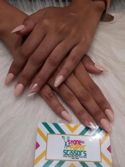 A minimalist and elegant design. The nails are painted in a soft nude color, with a single accent nail featuring a delicate white swirl for a touch of artistic flair.