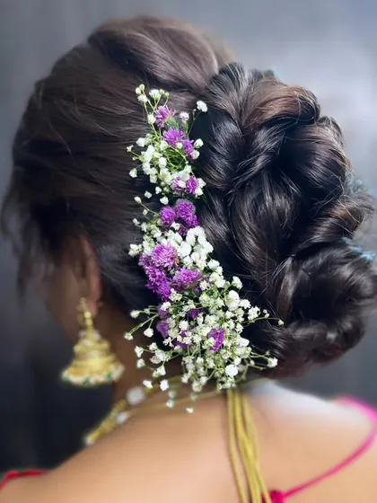 A beautiful floral bun for my Maharashtrian bride's engagement. The combination of purple and white baby's breath adds a touch of modern elegance to her traditional look.