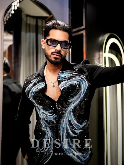 Sculpted in shimmer and styled to stun. This black shirt features abstract waves of blue and silver beadwork, creating a look of pure, refined edge for an unforgettable entrance.