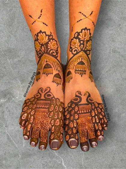 I also create beautiful and intricate mehendi designs for feet. This bridal feet design features majestic peacocks as the central element, with their feathers flowing down the feet, complemented by delicate jhumka and lotus details for a complete look.
