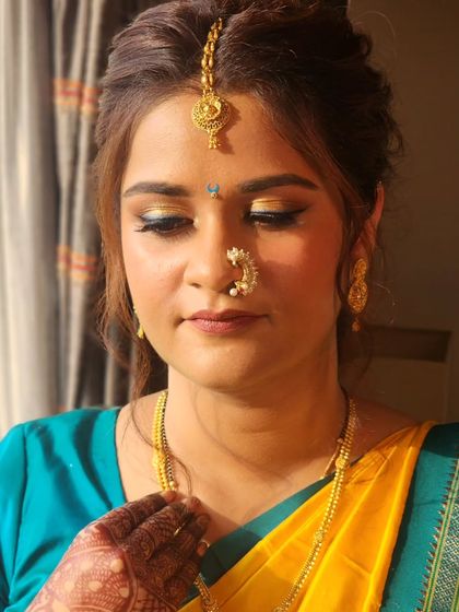 A close-up of the gold and blue eye makeup. This look is a great example of how to incorporate a pop of color while still keeping the overall style traditional and elegant.