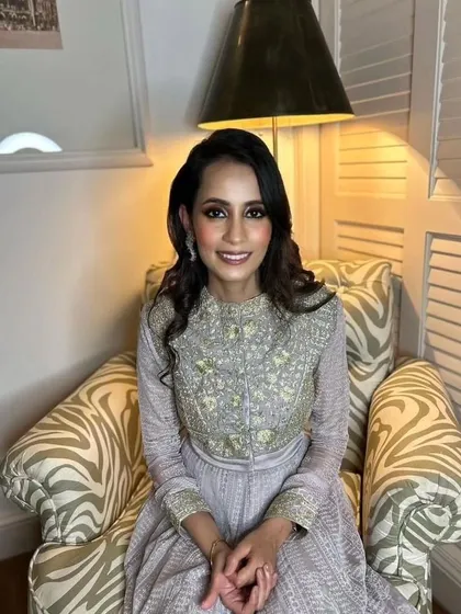 A sophisticated engagement look. The bride's elegant grey outfit is paired with a classic soft glam makeup look, perfect for a formal event.