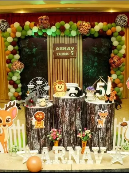 We love bringing wild adventures to life with our jungle themed birthday parties. This setup for Arnav's 5th birthday includes detailed animal cutouts, balloon trees, and log-style pedestals to create an immersive safari experience.