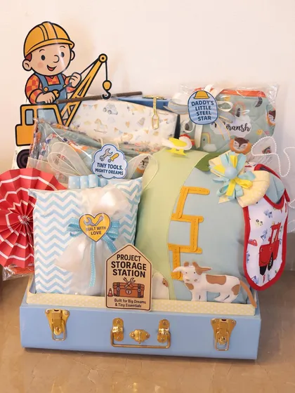 This is the 'Project Storage Station' hamper from the Bob the Builder set. I used a beautiful blue trunk and filled it with essentials like pillows, bibs, and blankets, all tied together with the construction theme.