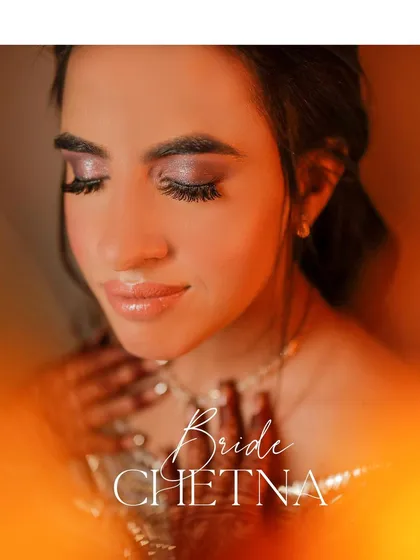 A close-up portrait of the bride, Chetna, with a warm, glowing light effect. This artistic shot highlights her stunning makeup and serene expression.