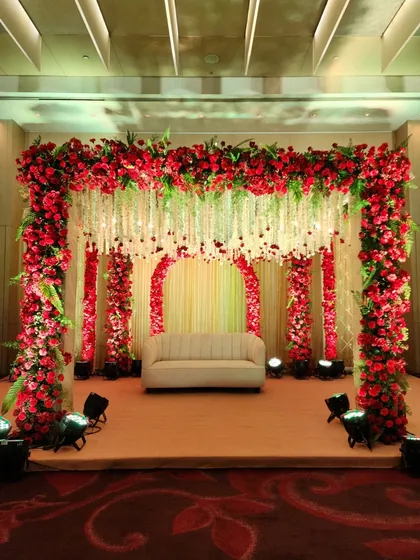 For a bold and passionate statement, we use a rich palette of red roses to create a stunning mandap and stage. The design features a canopy of flowers and hanging floral strings, enveloping the couple in traditional elegance.