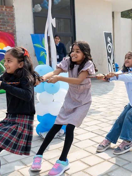 A fun game of tug-of-war at an outdoor party, with girls showing their strength and teamwork.