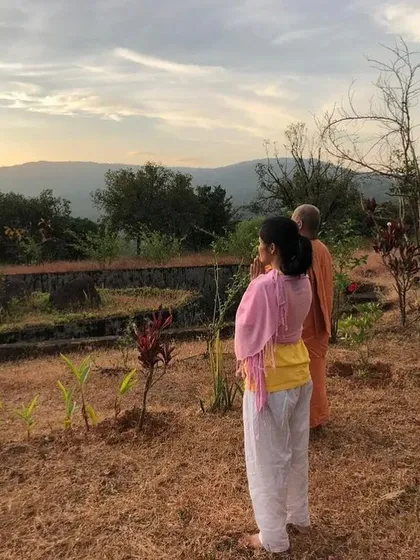 Students stand in prayer during a sunrise meditation at the Amboli ashram. This simple act of greeting the day with reverence is a key part of our Yoga Teacher Training Course discipline.