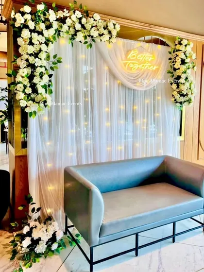 A simple and elegant 'Better Together' setup, perfect for a small restaurant or home space. The clean white floral arrangement on a backdrop of fairy lights is both beautiful and space-efficient.