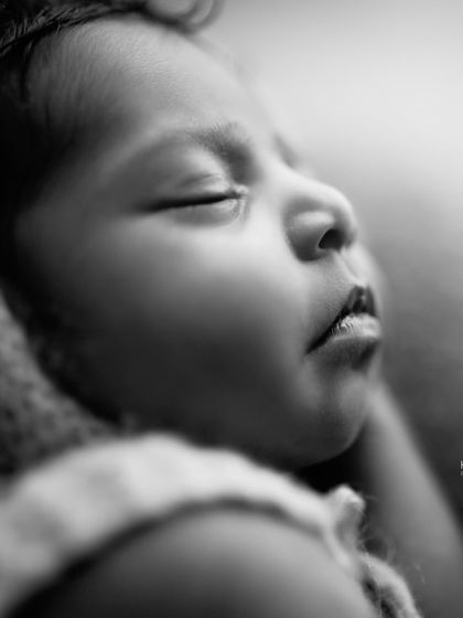 A black and white close-up of a newborn's face, highlighting their soft features and peaceful expression. The details are what make these portraits so sweet.