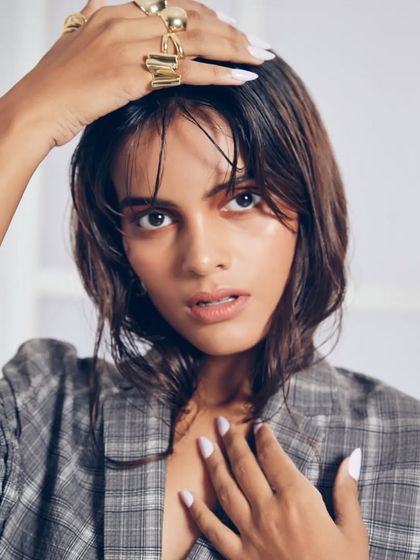 An edgy, contemporary look featuring a 'wet hair' style and a glossy, dewy skin finish. The subtle color wash on the eyes adds a touch of fashion-forward detail, perfect for a model's test shoot.