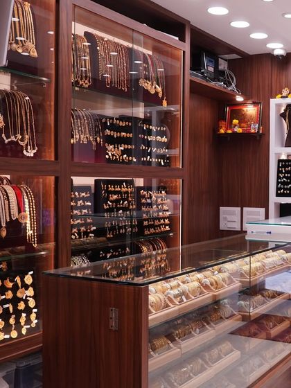 Another angle of my store's interior, showing the extensive collection of necklaces and earrings displayed in wooden and glass cabinets.