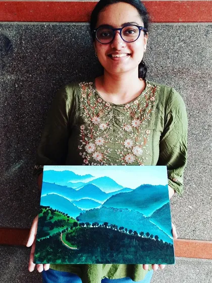 A student holds her painting of the tea plantations in Munnar, Kerala. We often use photographs of beautiful Indian landscapes as inspiration for our practice work.