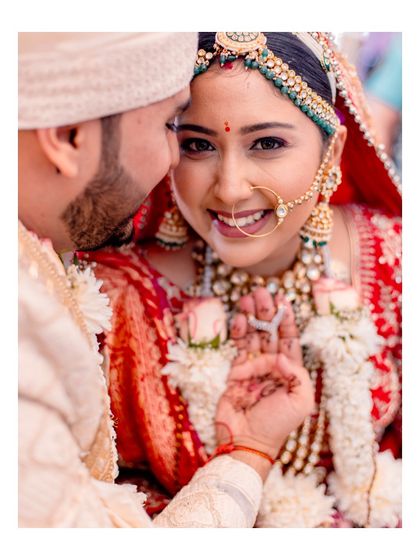 A quiet, intimate moment amidst the rituals. The groom's gentle touch and the bride's trusting gaze tell a story of their deep connection, a detail we always look for.