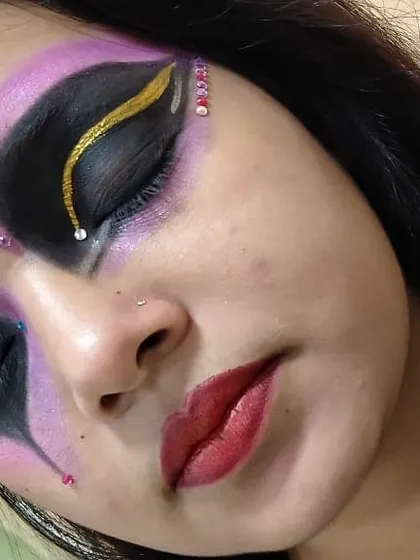 We encourage our students to push their creative boundaries. This is an example of fantasy makeup practice, focusing on advanced techniques like sharp graphic eyeliner, color blending with purple and black, and precise rhinestone application.