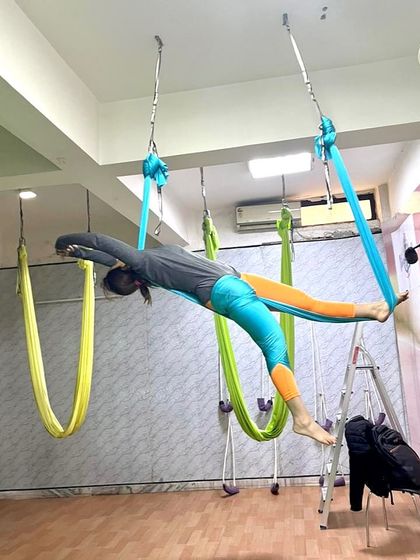 As a yoga instructor, taking my practice to the sky is a passion. This pose, a variation of the flying pigeon, is a deep hip opener that also challenges balance and core strength.