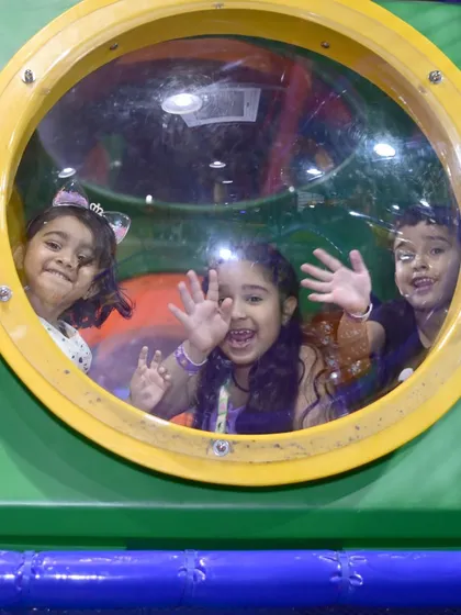 Waving hello from inside one of the tunnel portholes. Our play structure is full of fun nooks and windows for kids to peek out from.