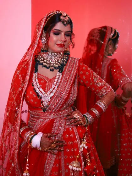 A close up of this stunning bridal makeup, showing the flawless base and expertly blended eyeshadow. The red lip and defined eyes create a powerful yet elegant look.