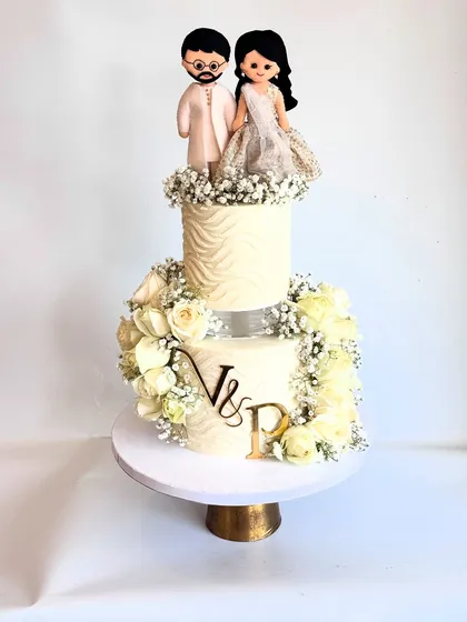 This gorgeous two-tier cake was for a glitzy engagement ceremony. It features a 3kg Chocolate-Dulce de Leche cake with a spacer, fresh flowers, and a custom couple topper.