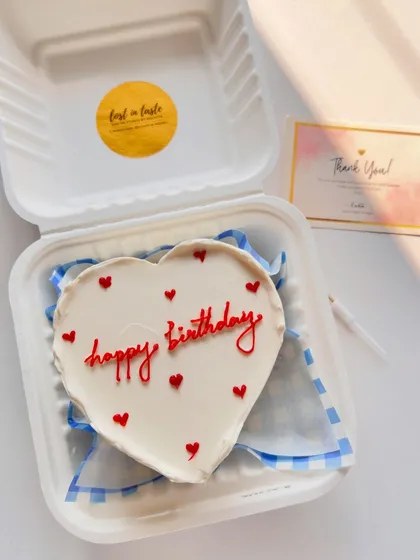 A classic heart-shaped birthday cake. The simple "happy birthday" in red script surrounded by tiny hearts is a timeless way to show you care.