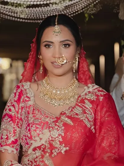 A close-up of the beautiful bride as she walks towards the mandap, her path illuminated by the love of her family and the stunning decor.