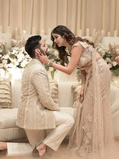 A tender moment as the bride-to-be caresses the groom's face after his proposal.