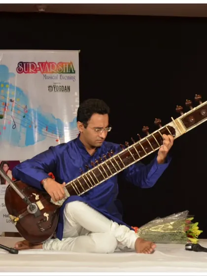 Performing Raag Kedar at the India Habitat Centre. The stage setup is clean and traditional, ensuring the focus remains entirely on the music.