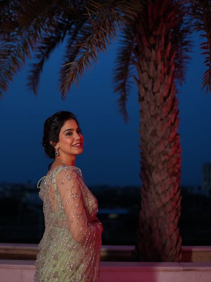 A smiling portrait against the night sky. The subtle sparkle of the saree looks beautiful in the evening light.