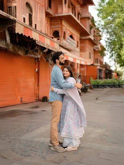 A warm embrace in front of the iconic terracotta-colored buildings of Jaipur's old city.