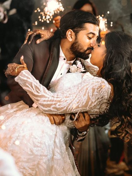 A romantic dip and kiss surrounded by the warm glow of sparklers. A perfect end to a perfect day.