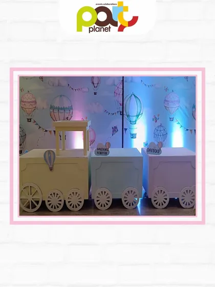 Custom-made train-cart tables for kids, set against a hot air balloon wallpaper, adding a unique and playful touch to the party decor.
