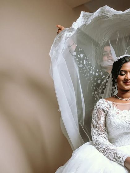 A beautiful shot of the bride being "unveiled" by her bridesmaids, a playful take on a traditional moment.