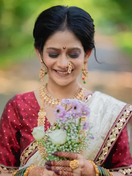 A serene bride holding a bouquet. The soft makeup and her gentle smile create a picture of pure elegance.
